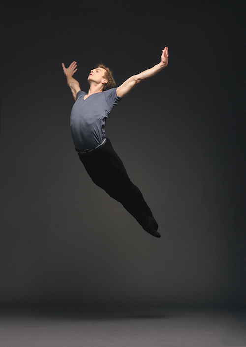 Gennadi Nedvigin is airborne. Both of his legs are together in the air. His head tosses back with his arms outstretched.